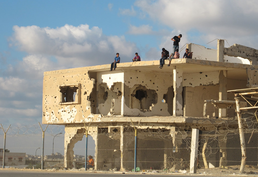 Palestinian children sit on a blown up building wall in Gaza.