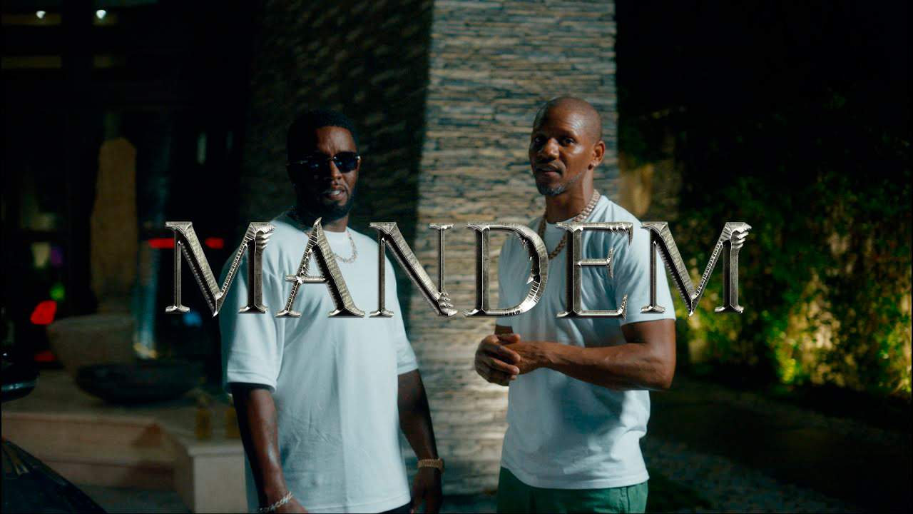 Diddy and uk hip-hop artist giggs stand alongside each other outside a hotel