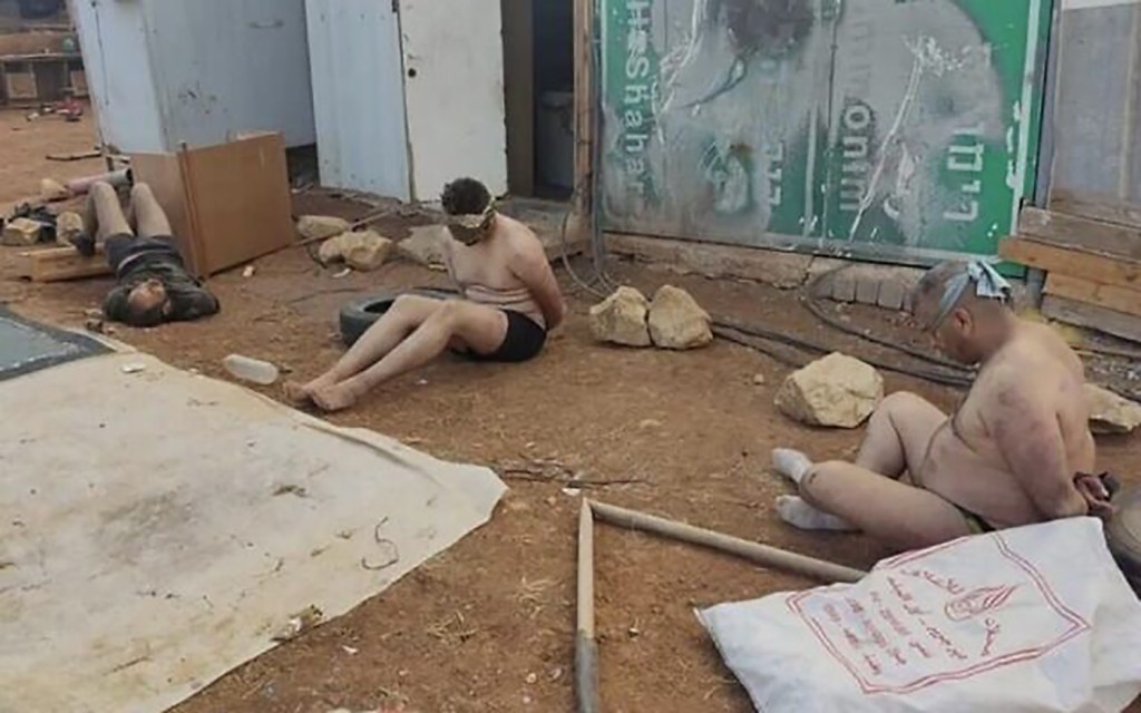 Two Palestinian prisoners can be seen bound and blindfolded having had their clothes stripped. They're in an abandoned house.