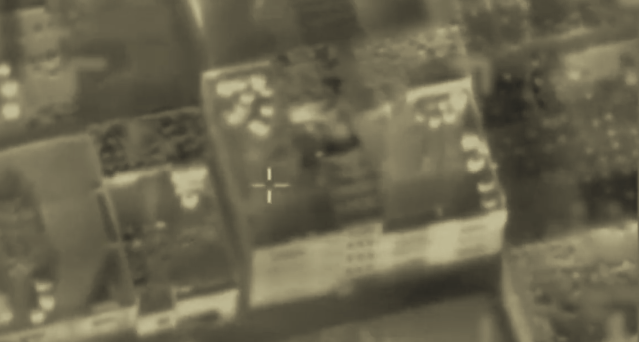An image shows an alleged Hamas hideout being destroyed by the Israeli air force. It is in black and white due to a night vision capture. The building is a square structure.