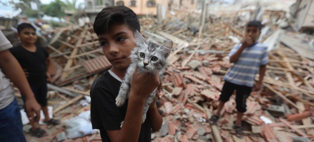 Two boys walk amid Gaza's post-Israeli airstrikes rubble, amidst devastation, yet with hopeful eyes.