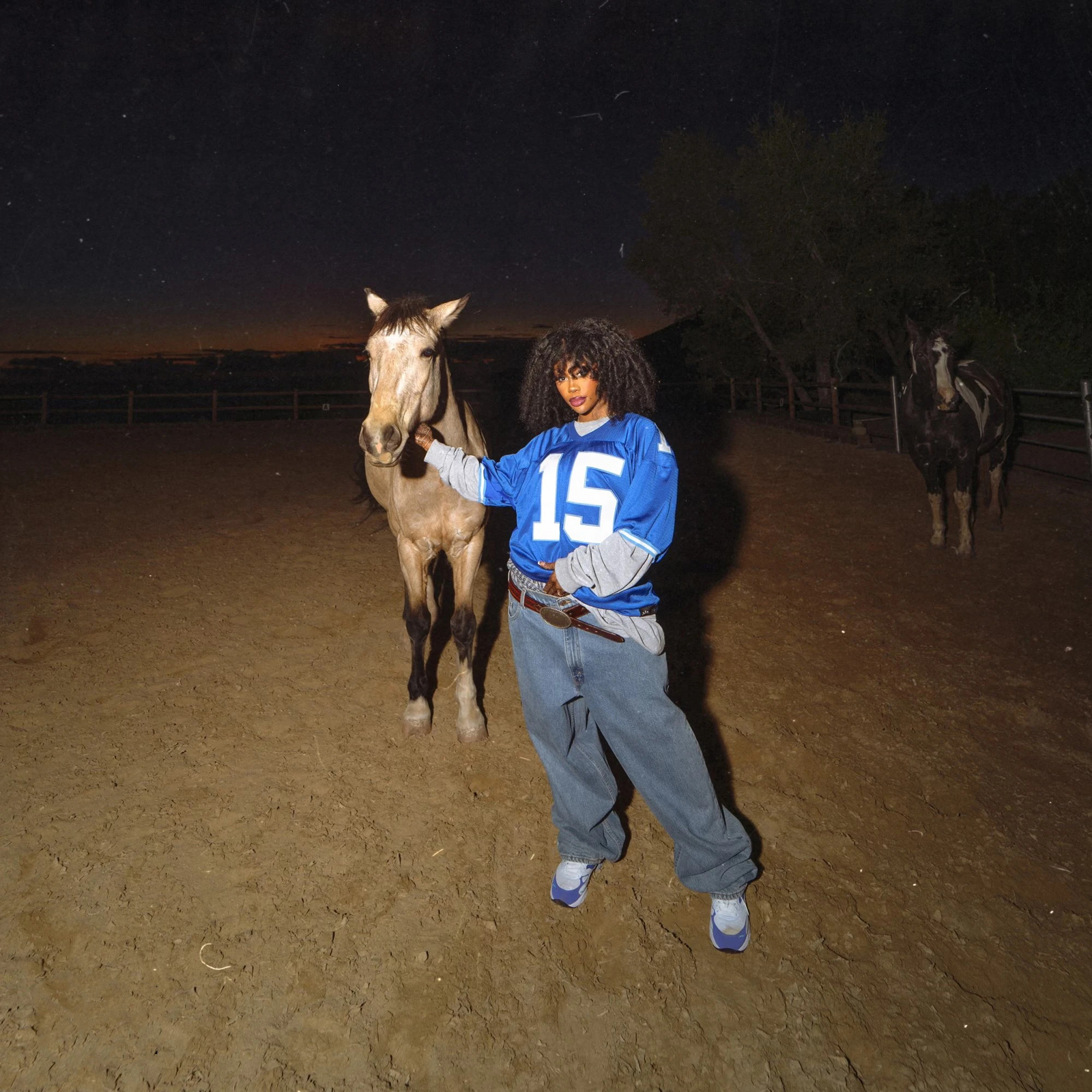SZA stands with a horse in a ranch at night for her new albun 'Lana.'