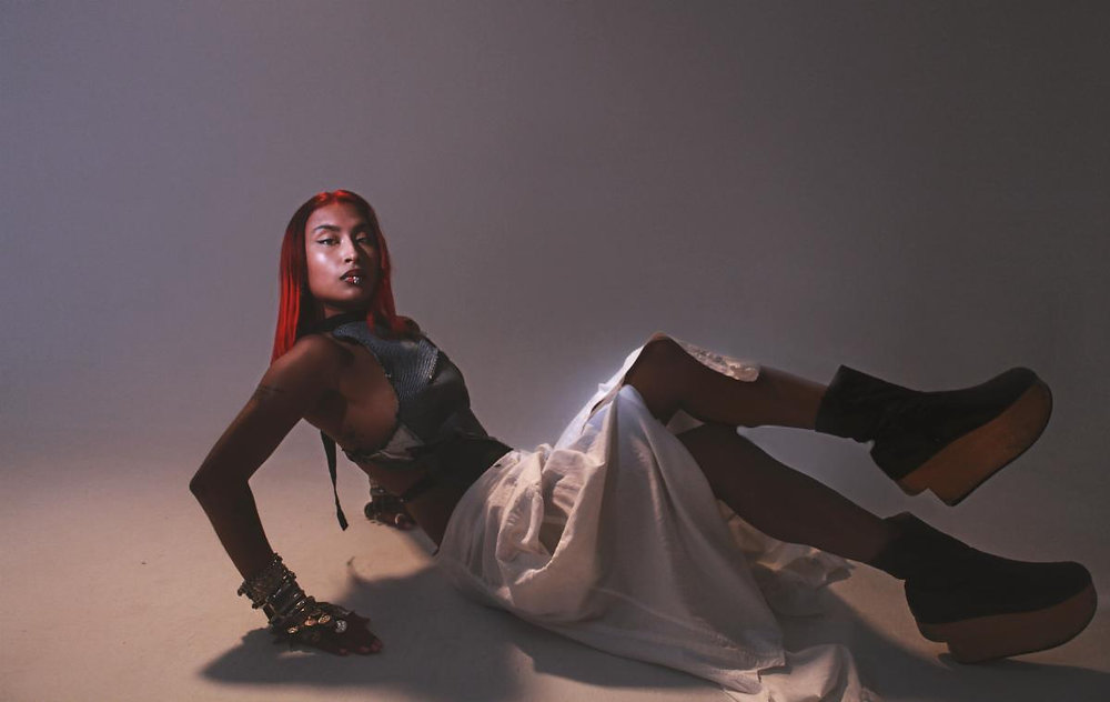 Singer Aanya Martin lies down on the floor in a smoky studio.