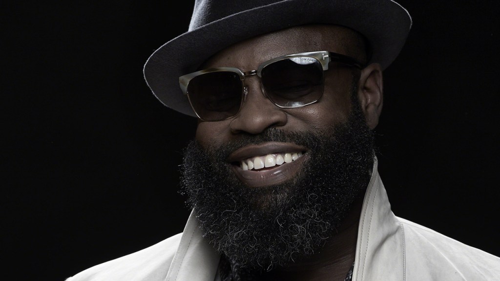 Black Thought picture smiling wearing his trademark hat and sunglasses.
