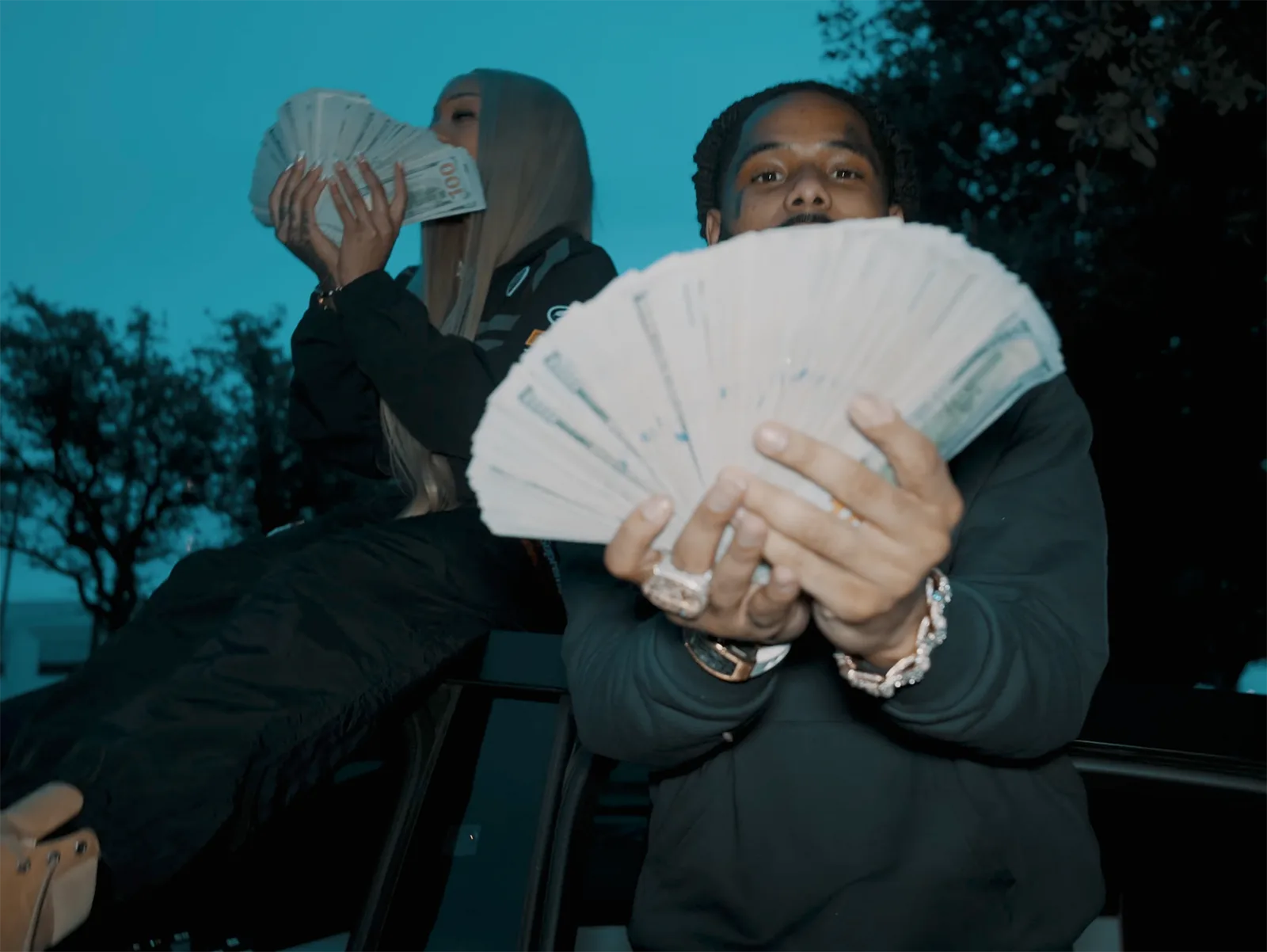 GloRilla and Pooh Shiesty in a still from the โManeโ music video celebrating success and holding wads of cash, representing Memphis hip-hop