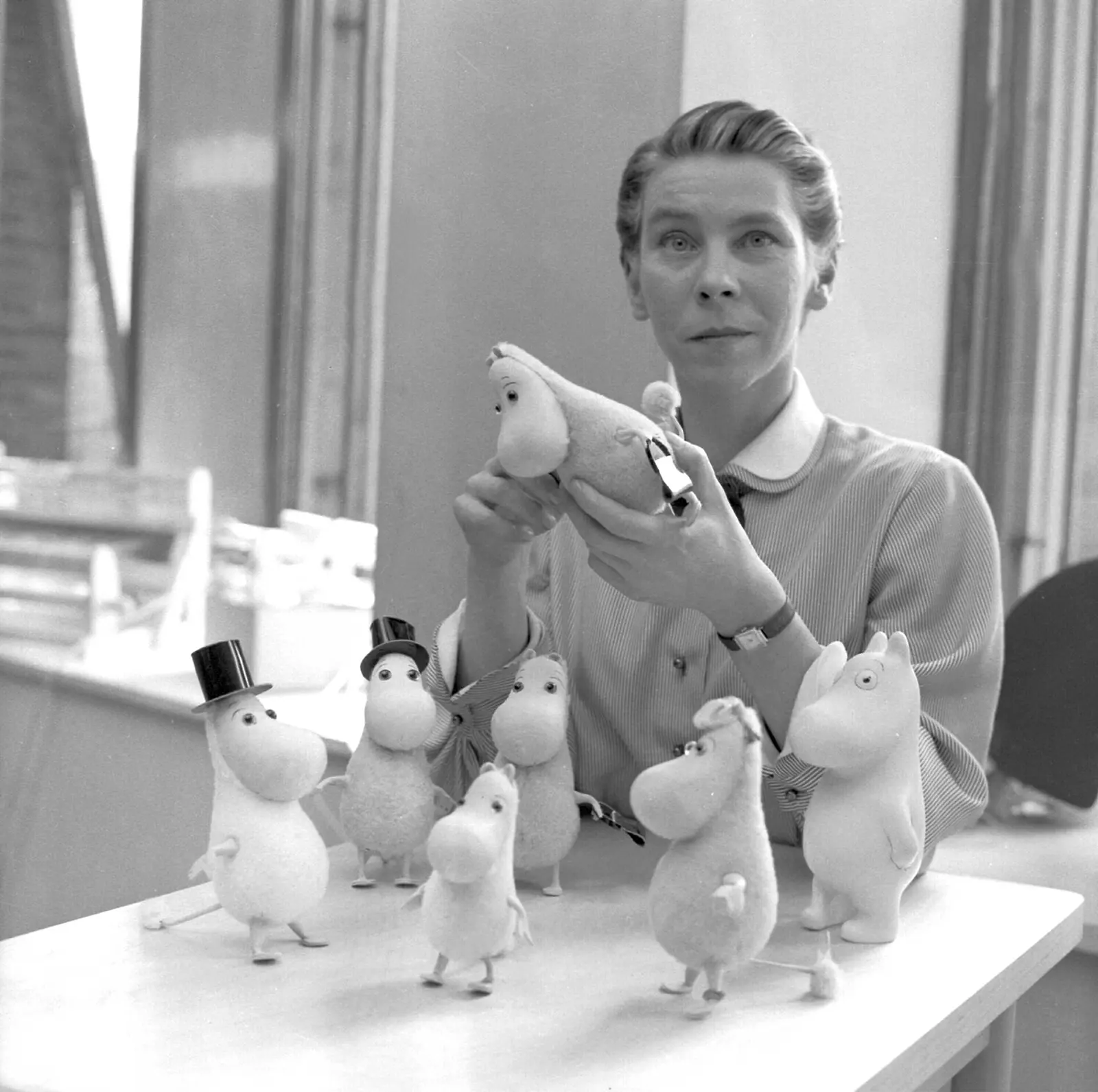 Finnish artist and writer Tove Jansson pictured with several Moomin figures in 1956.
